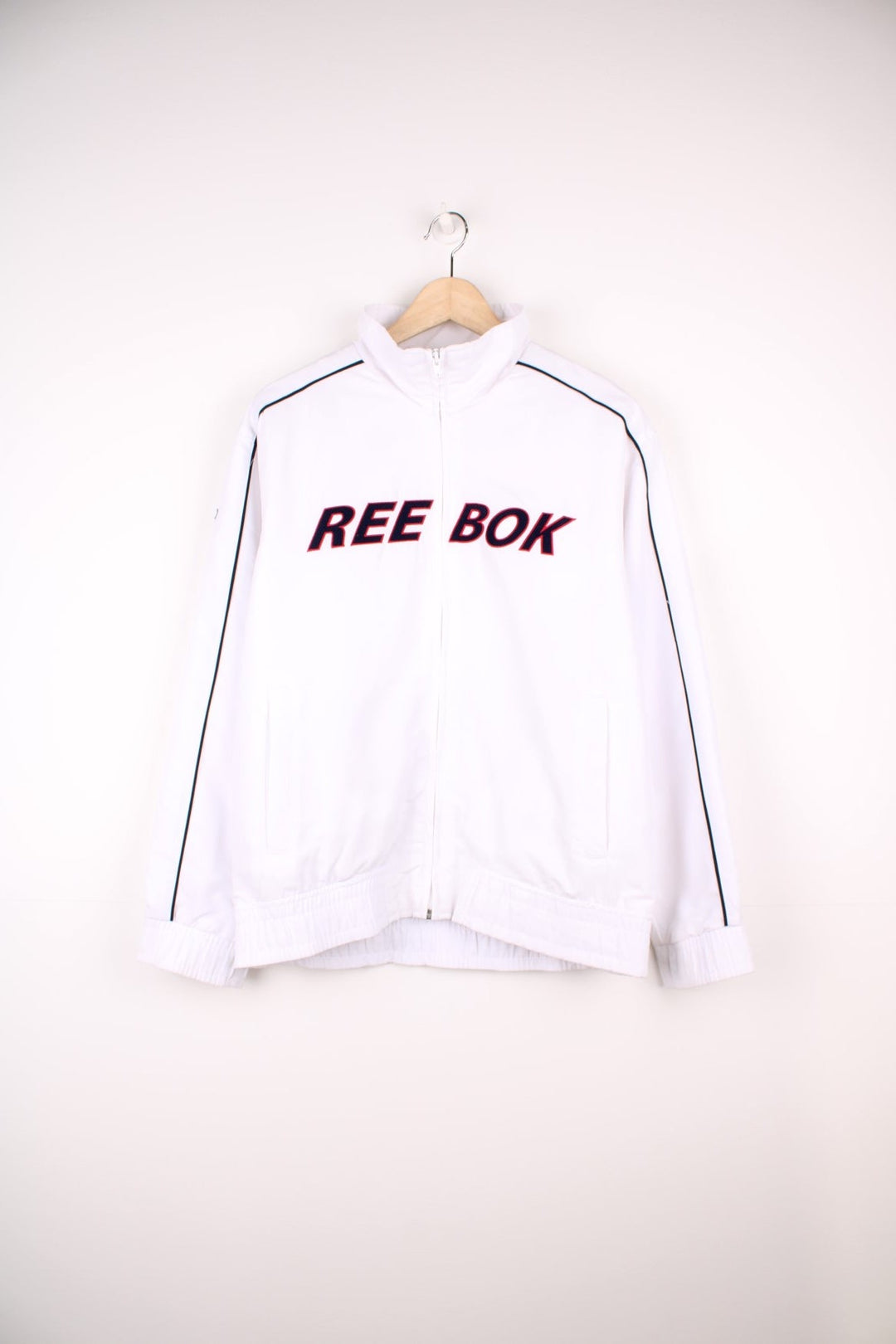 White Reebok tracksuit top with embroidered spell out logo across the chest.