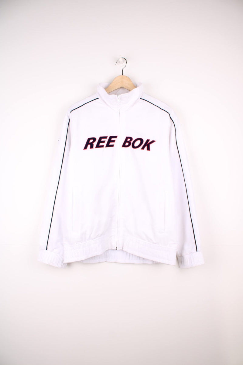 White Reebok tracksuit top with embroidered spell out logo across the chest.