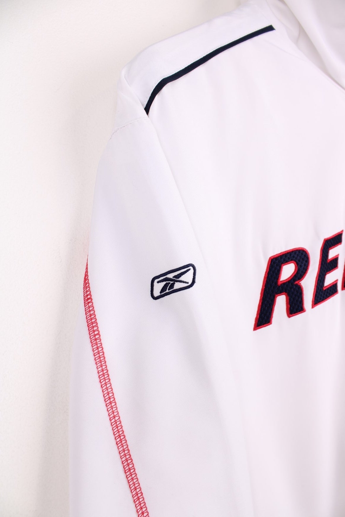 White Reebok tracksuit top with embroidered spell out logo across the chest.