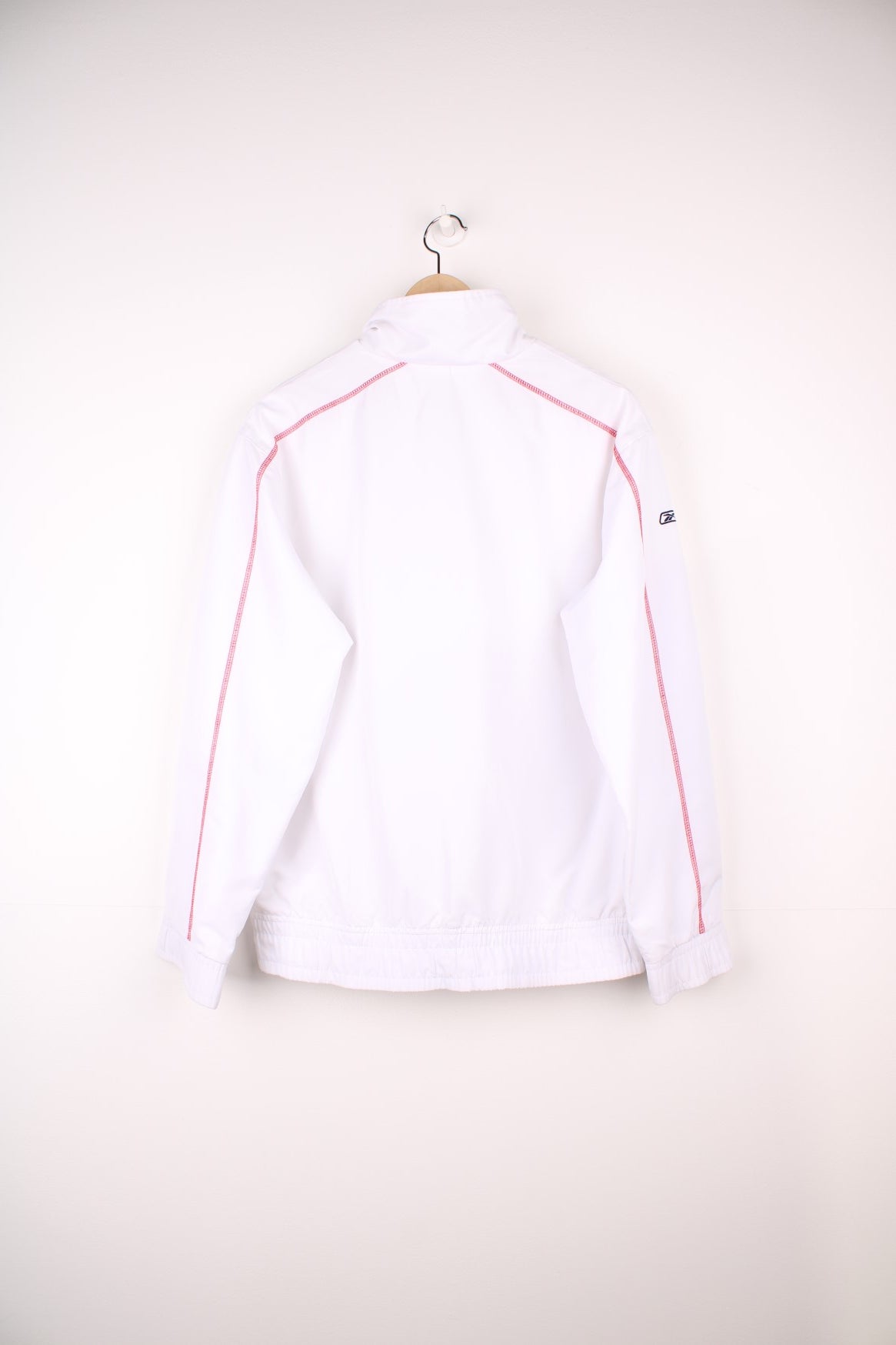 White Reebok tracksuit top with embroidered spell out logo across the chest.