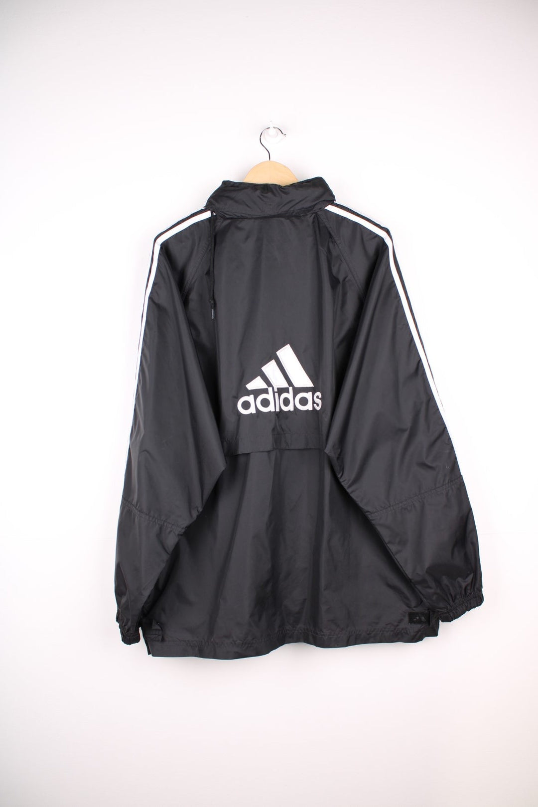  Windbreaker in a  colourway with the iconic three stripes going down the sleeves, zip up closure, has multiple pockets, hidden hood, and the logo embroidered on the front and larger on the back.