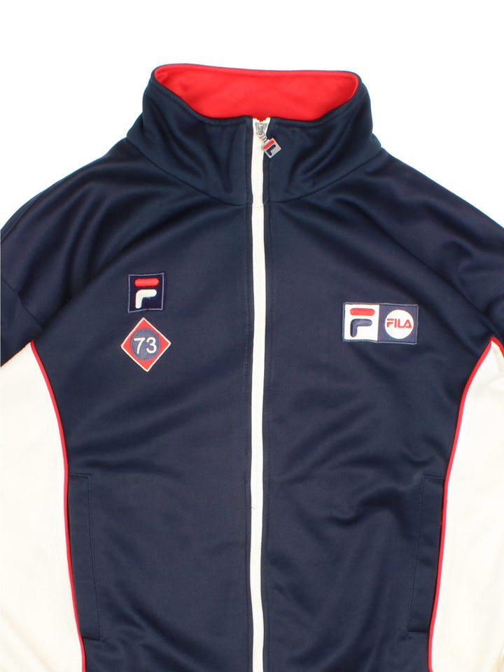 Vintage Fila Tracksuit Jacket in a blue, red and white colourway. Zips up and has side pockets, and the logos embroidered on the front.