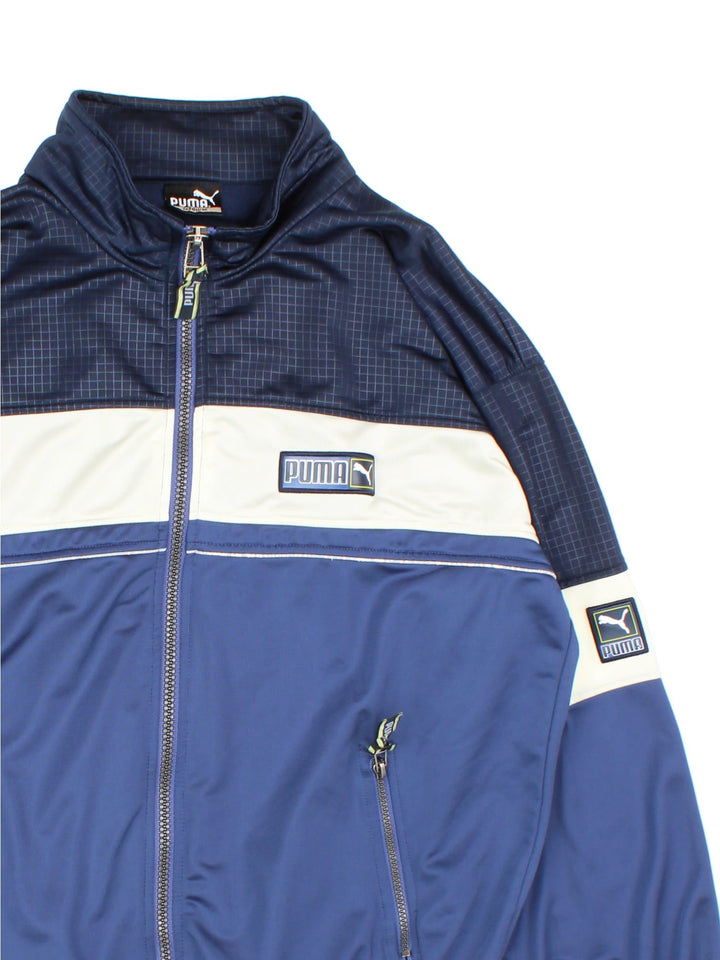 Vintage Puma Tracksuit Jacket in a blue and white colourway. Zips up and has side pockets, and the logo embroidered on the front.