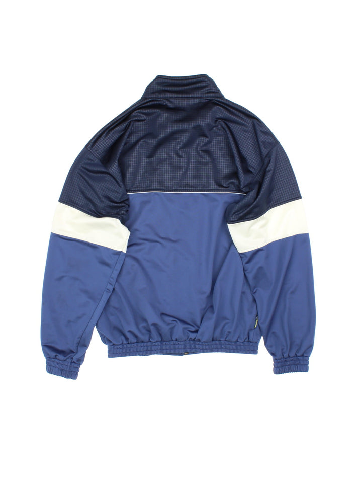 Vintage Puma Tracksuit Jacket in a blue and white colourway. Zips up and has side pockets, and the logo embroidered on the front.