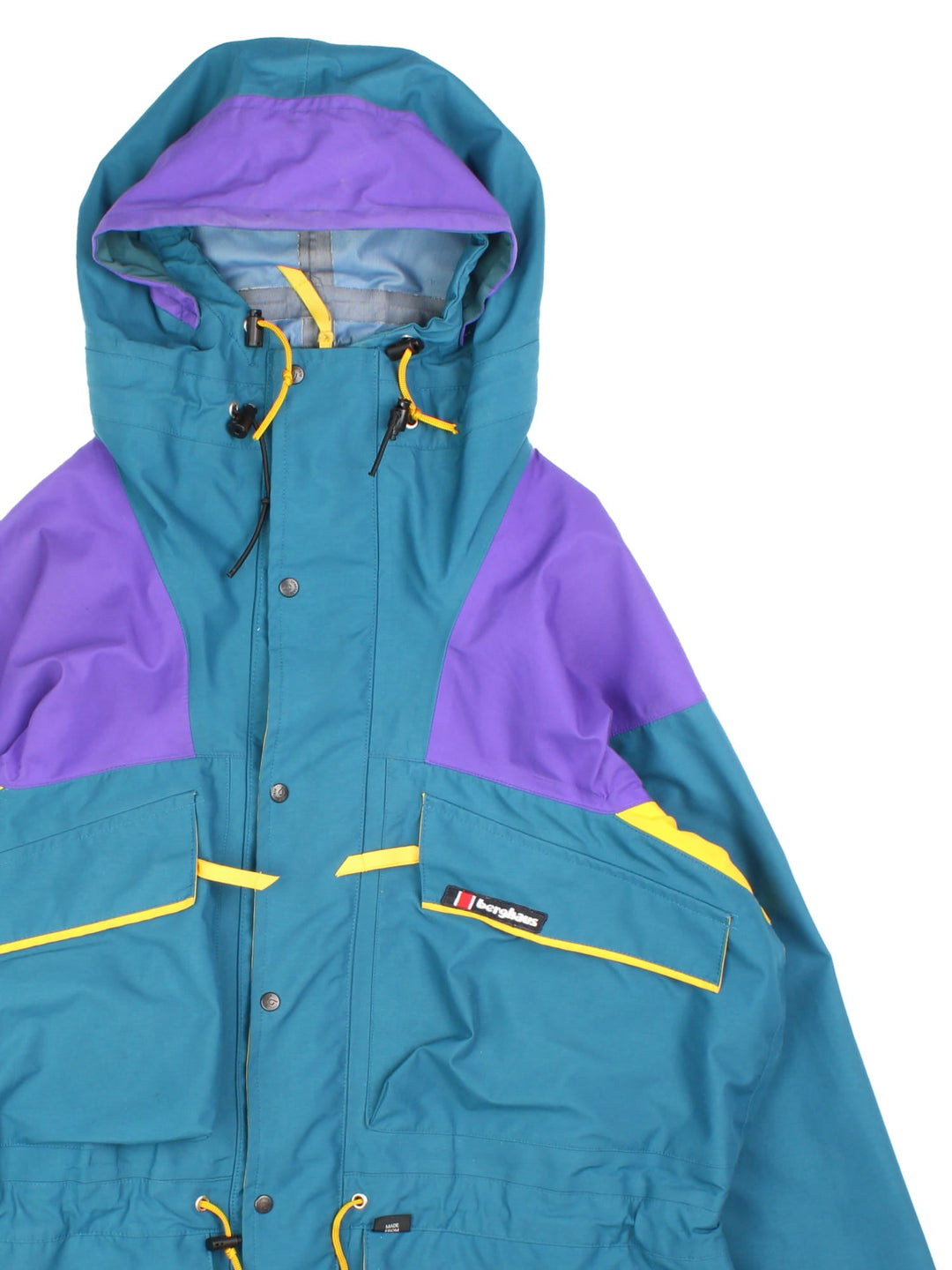 Vintage Berghaus Trango Jacket in a blue, purple and yellow colourway. Zips and buttons up, has multiple pockets, hooded, and the logo embroidered on the front.