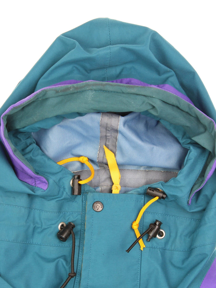 Vintage Berghaus Trango Jacket in a blue, purple and yellow colourway. Zips and buttons up, has multiple pockets, hooded, and the logo embroidered on the front.