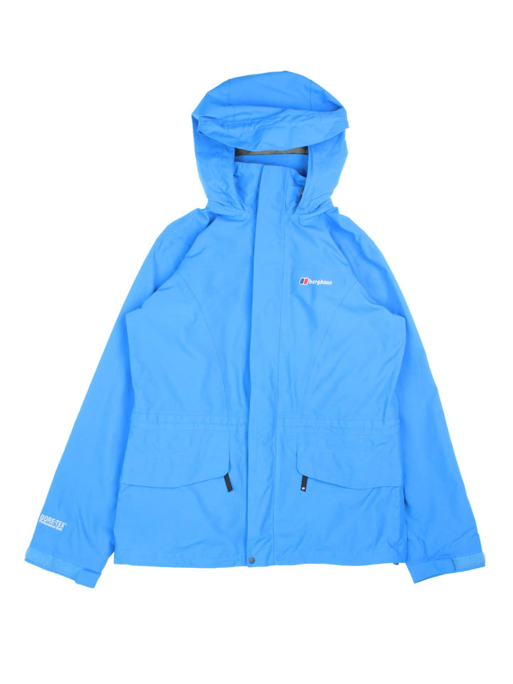 Berghaus Gore-Tex Jacket in a blue colourway. Zips up and has side pockets, mesh lining, hooded, and has the logo embroidered on the front.