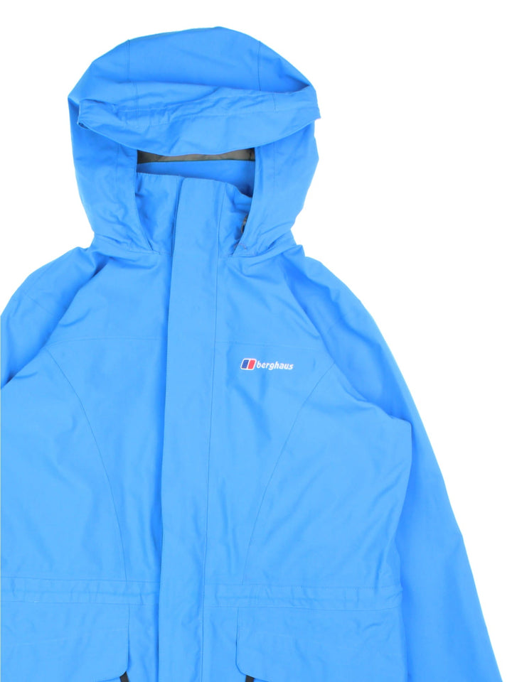 Berghaus Gore-Tex Jacket in a blue colourway. Zips up and has side pockets, mesh lining, hooded, and has the logo embroidered on the front.