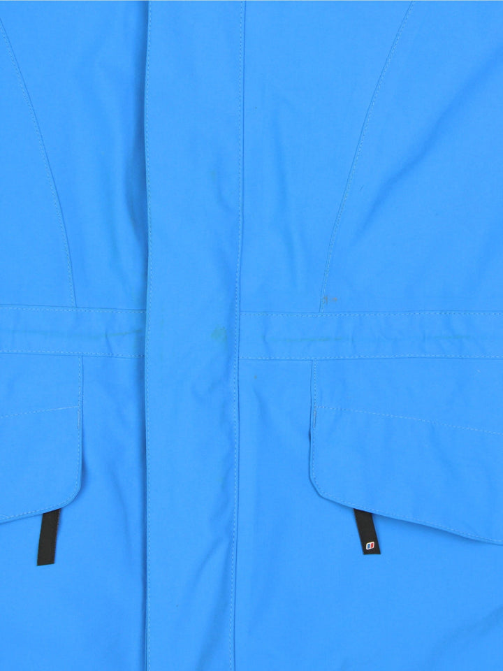 Berghaus Gore-Tex Jacket in a blue colourway. Zips up and has side pockets, mesh lining, hooded, and has the logo embroidered on the front.