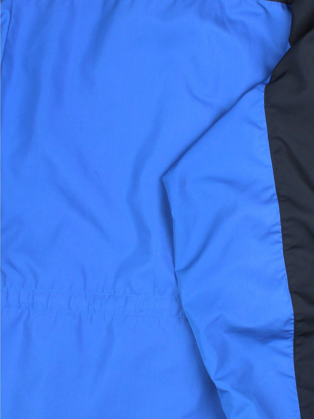 Vintage Paramo Nikwax Jacket in a blue and black colourway. Zips and buttons up, has side pockets, insulated lining, hooded, and has the logo embroidered on the front amd on the right sleeve.