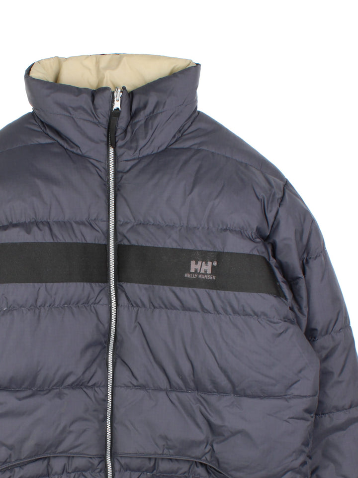 Vintage Helly Hansen Reversible Puffer Coat in either a black or beige colourway options. Zips up and has side pockets, insulated lining, and has the logo embroidered on the front and back.