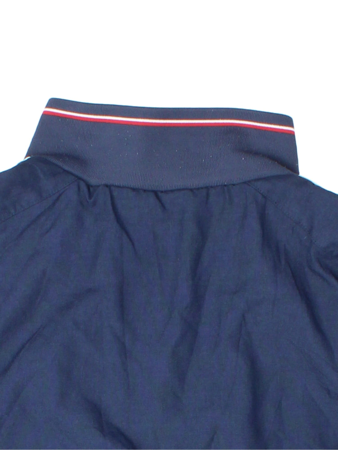 Vintage Nike 1/4 zip reversible pullover track top in navy blue with two zipped pockets, red and white stripe detailing, and a logo on the sleeve. Reverse side is red with blue and white stripe detailing. Swoosh embroidered on the chest of both sides.