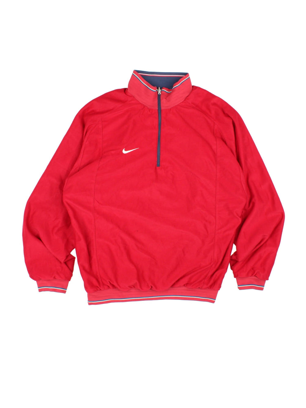 Vintage Nike 1/4 zip reversible pullover track top in navy blue with two zipped pockets, red and white stripe detailing, and a logo on the sleeve. Reverse side is red with blue and white stripe detailing. Swoosh embroidered on the chest of both sides.