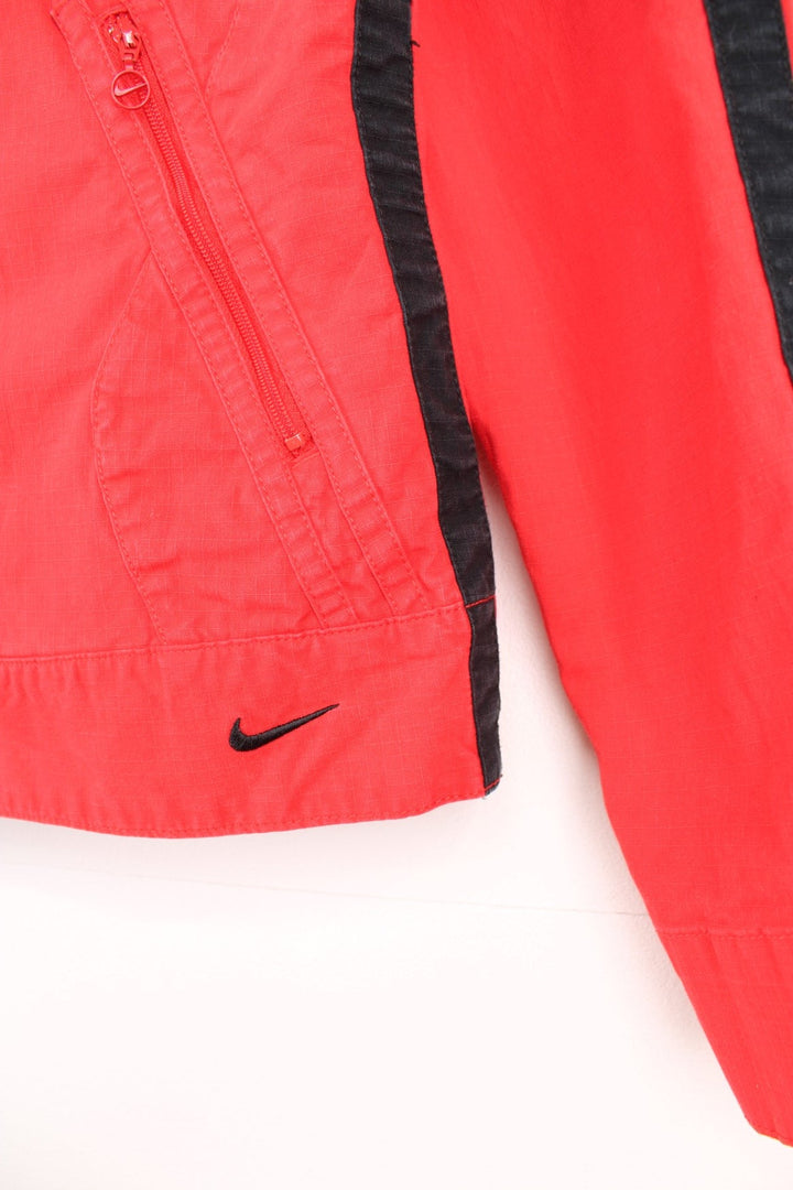 Red Nike zip through jacket featuring embroidered logo and black stripe down each sleeve.