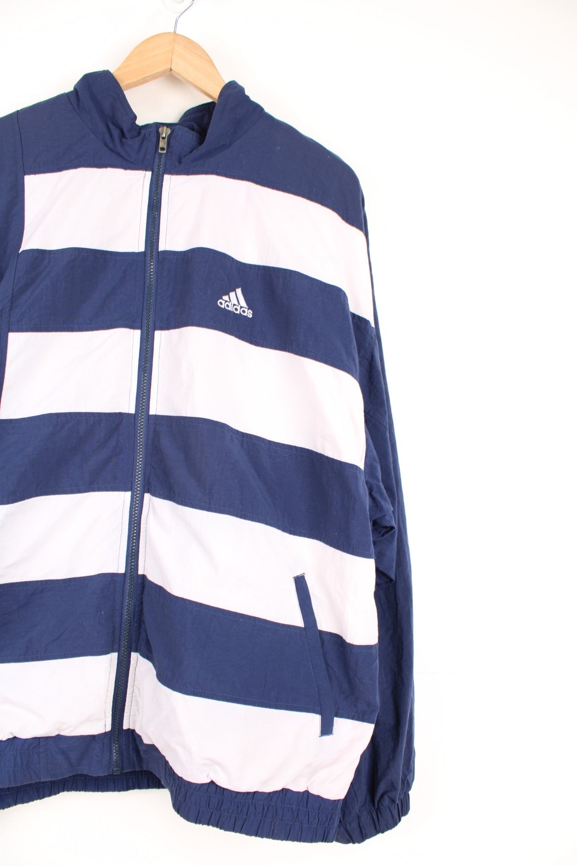 Blue and white Adidas striped tracksuit top. Features embroidered logo on the chest.