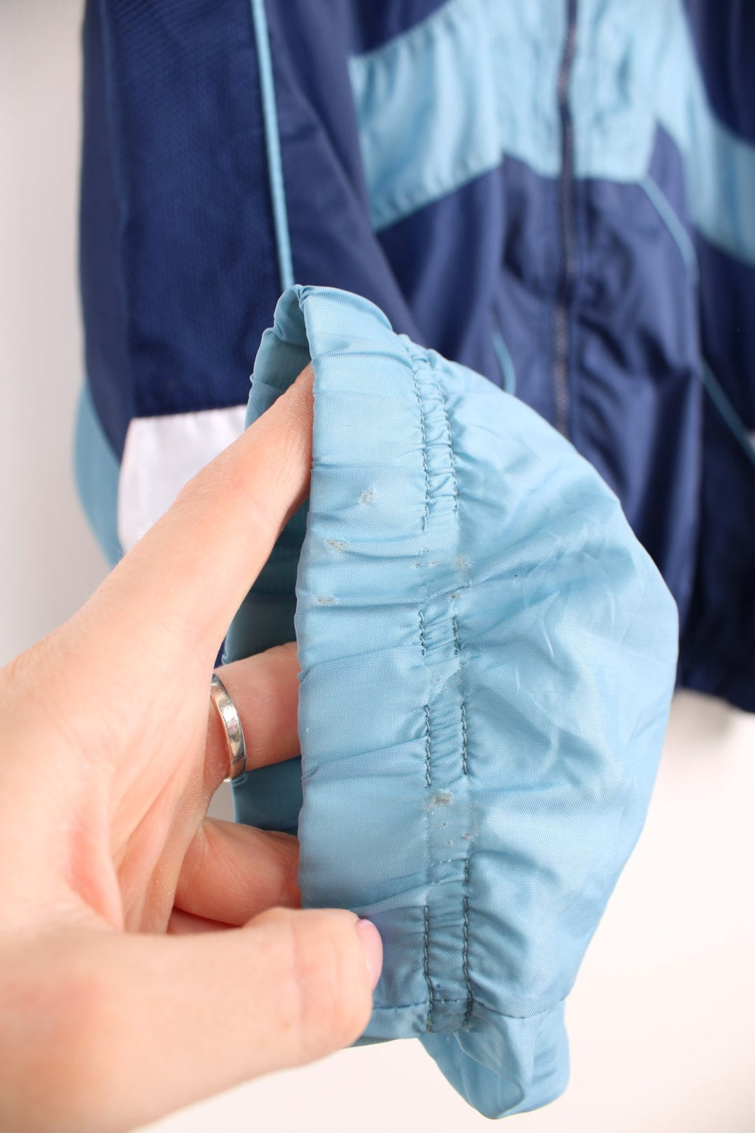 Vintage 90s Nike tracksuit top with blue and white panelling details and embroidered logo on the front and back.