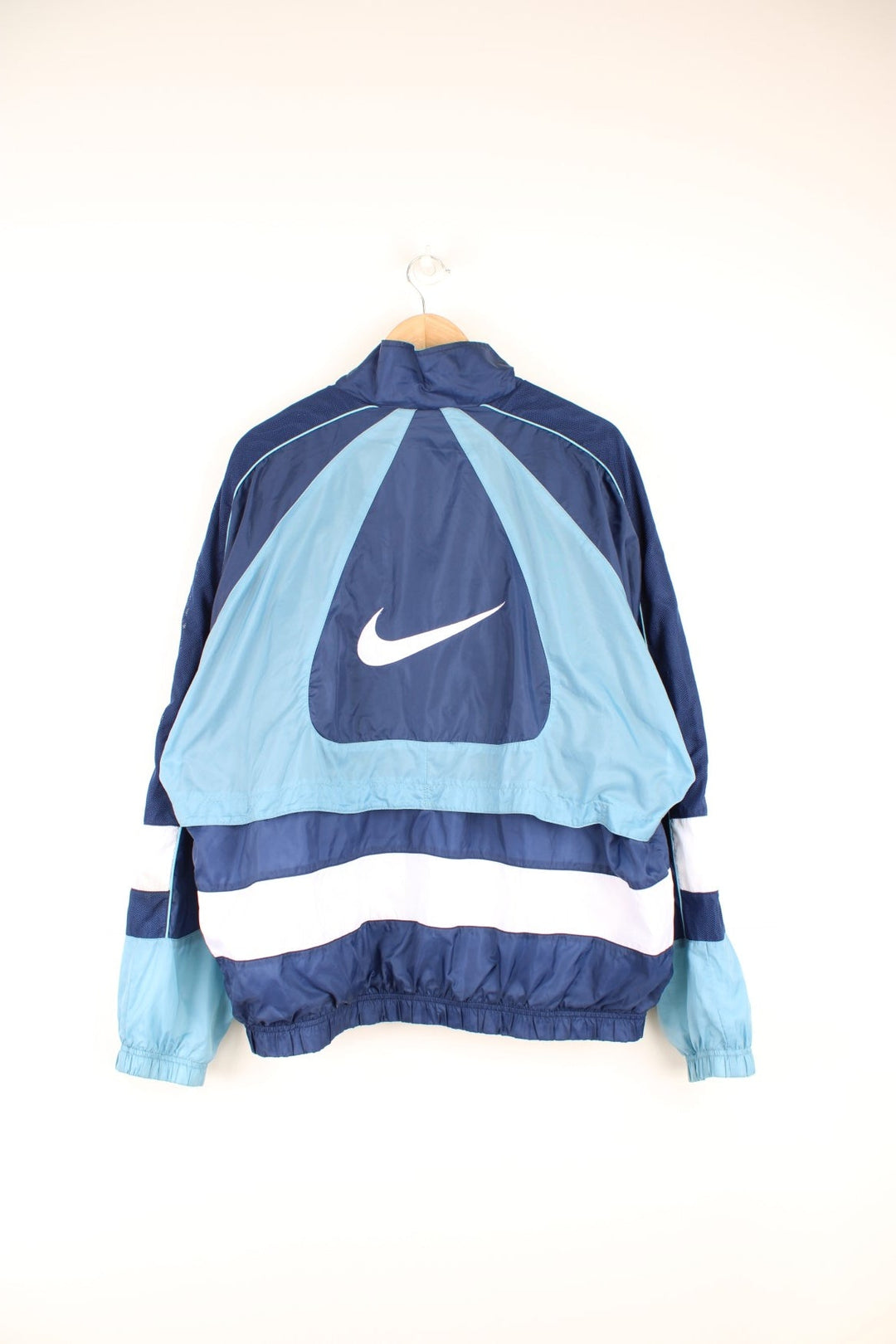 Vintage 90s Nike tracksuit top with blue and white panelling details and embroidered logo on the front and back.