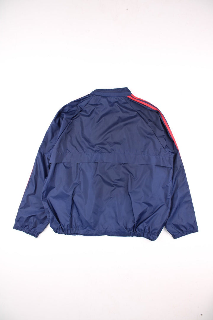 Vintage Adidas Trefoil Windbreaker Jacket in navy blue, with red three-stripe, two pockets, zip closure, a hidden hood, and the logo on the front.