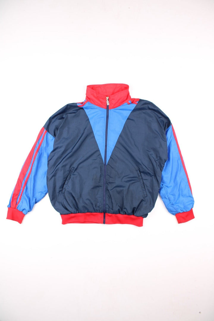 Vintage Sergio Tacchini track jacket in navy blue, with red and blue panelling, two pockets, zip closure, and an embroidered logo on the sleeve.