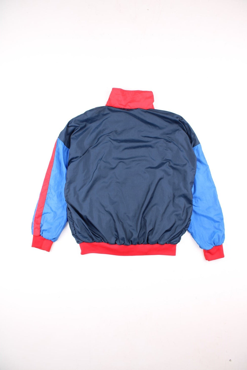 Vintage Sergio Tacchini track jacket in navy blue, with red and blue panelling, two pockets, zip closure, and an embroidered logo on the sleeve.