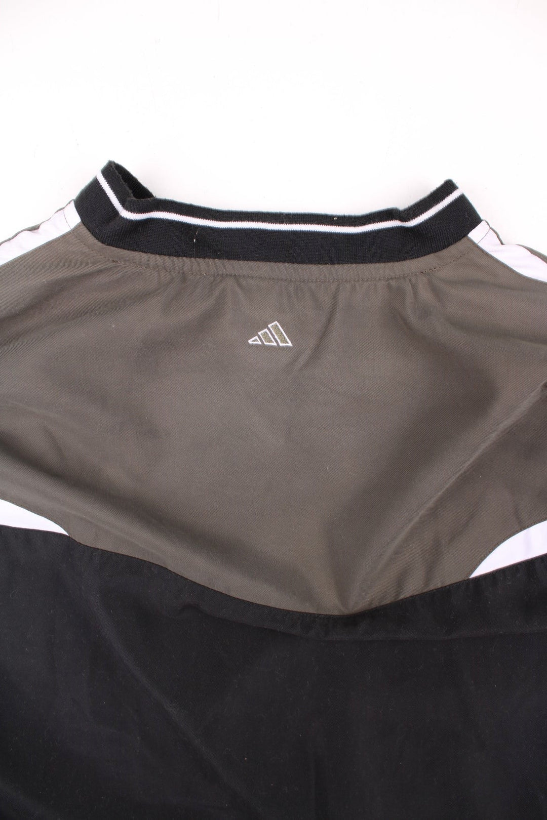 Adidas Golf v-neck pullover drill top in black, with green and white panelling, and has the logo embroidered on the front.