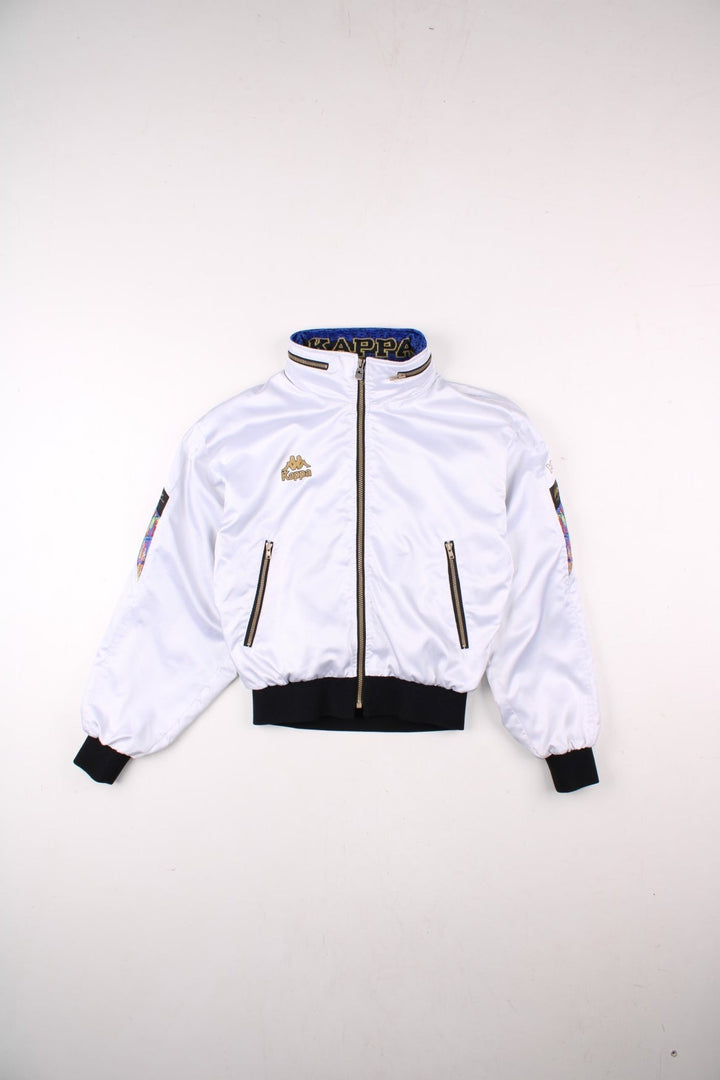 Vintage Kappa Lightweight Bomber Jacket in white, with black hem and cuffs, colourful patches on each sleeve, two pockets, hidden hood, zip closure, and a printed logo on the chest.