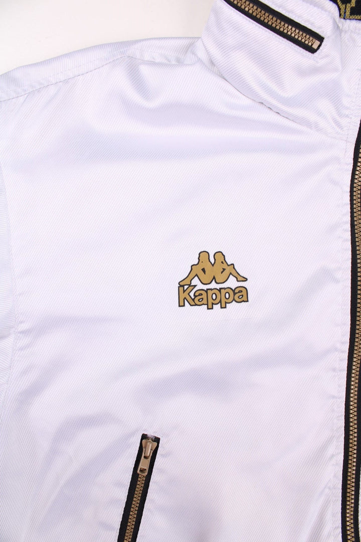 Vintage Kappa Lightweight Bomber Jacket in white, with black hem and cuffs, colourful patches on each sleeve, two pockets, hidden hood, zip closure, and a printed logo on the chest.