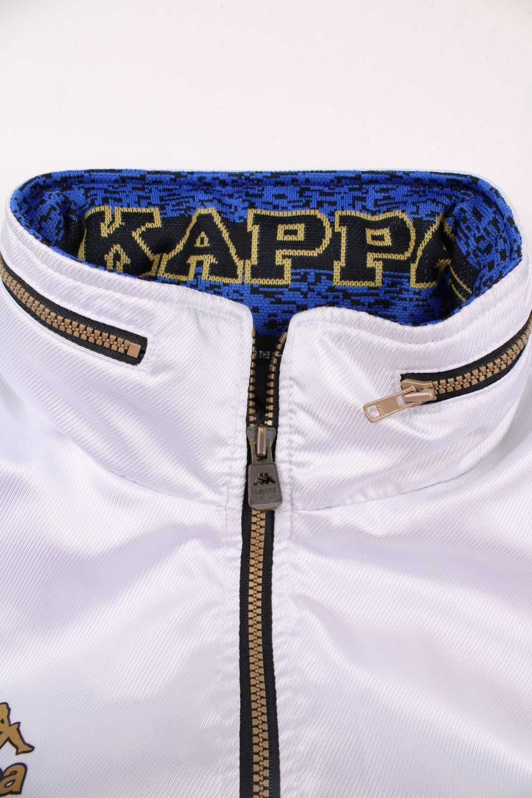 Vintage Kappa Lightweight Bomber Jacket in white, with black hem and cuffs, colourful patches on each sleeve, two pockets, hidden hood, zip closure, and a printed logo on the chest.