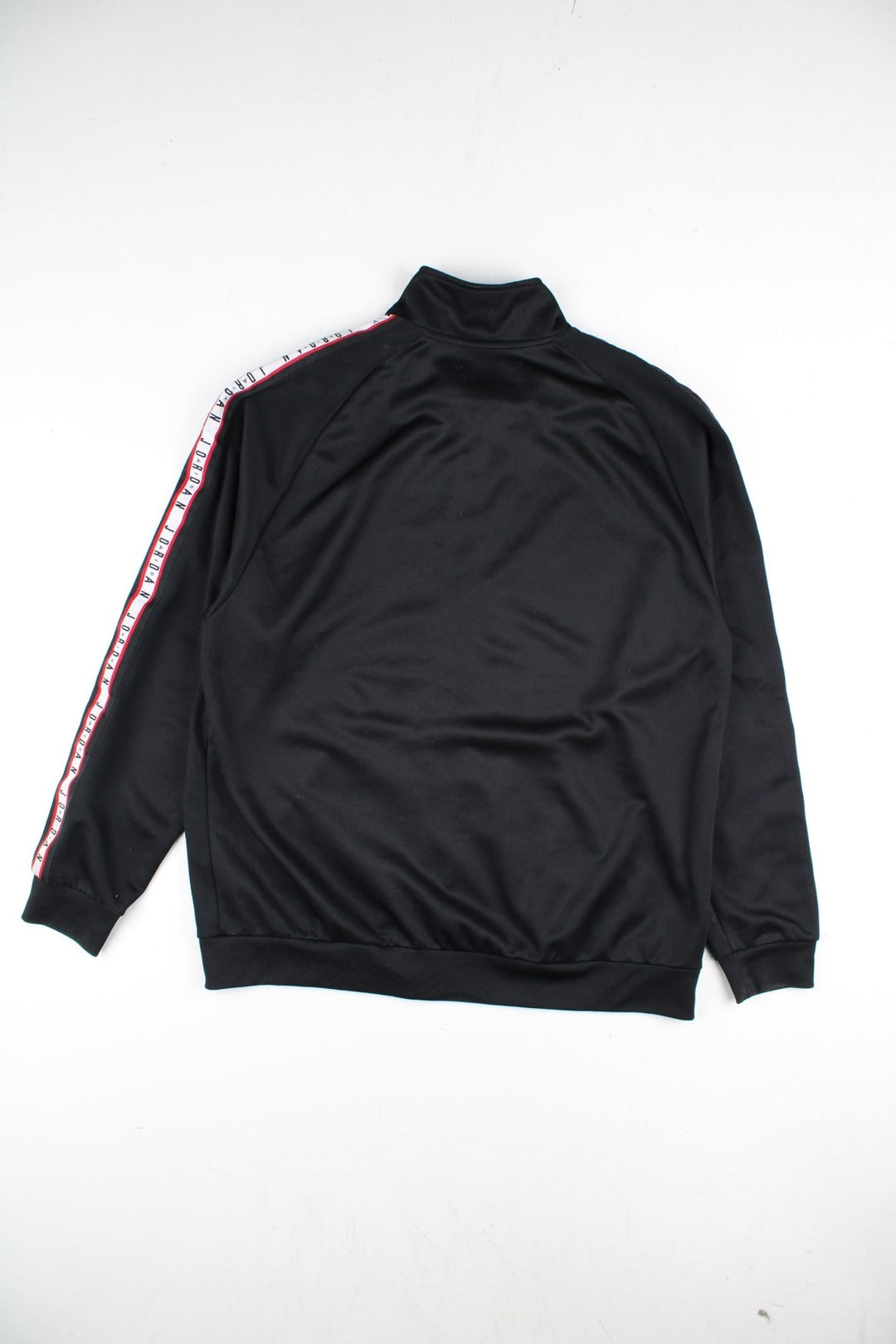 Vintage Air Jordan Track Top in a black colourway with Air Jordan stripe down the sleeves and classic logo on the front. Full zip with double front pocket.