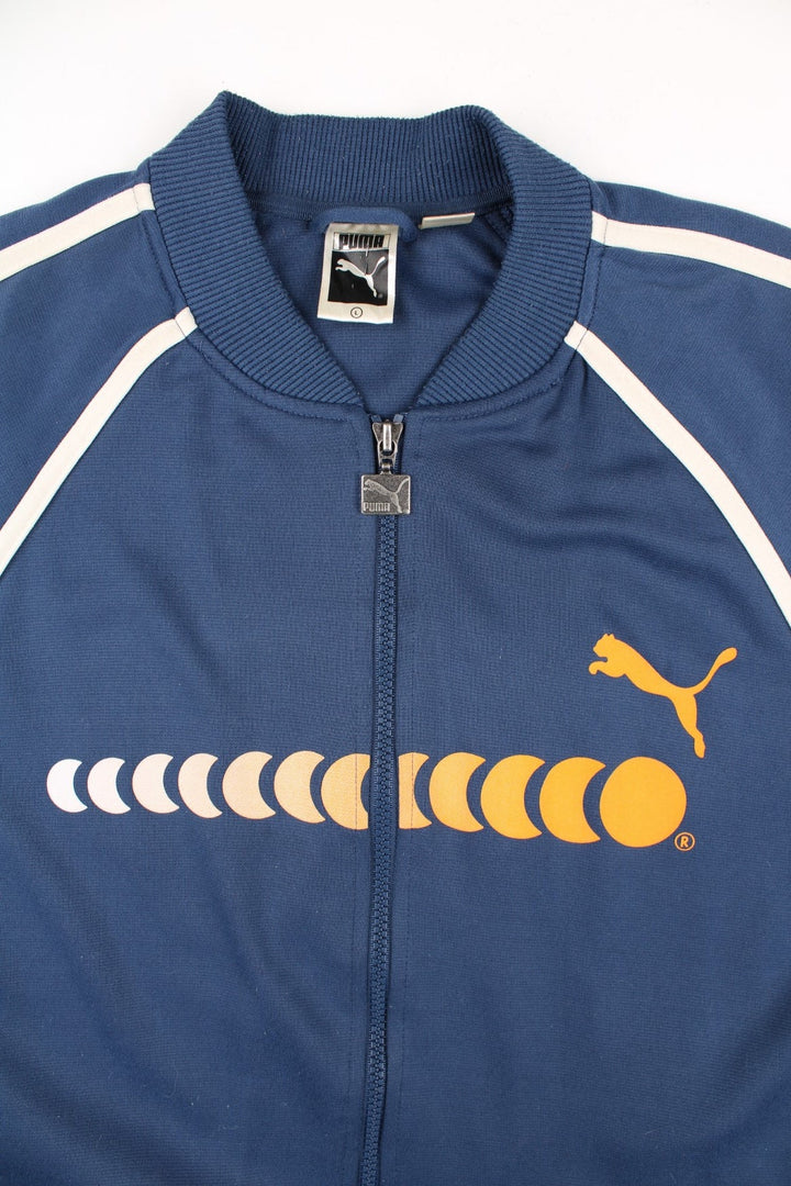 90's Puma Track Top in a blue colourway with yellow logo across the chest. White stripe along the sleeves and front with a full zip.