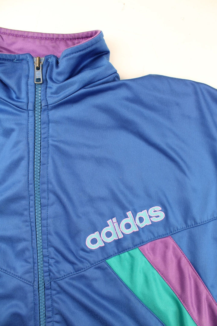 Vintage Adidas Track Top in a blue colourway with small green and purple stripes on front and the sleeve. Full zip with two zip pockets and small classic logo on the front.