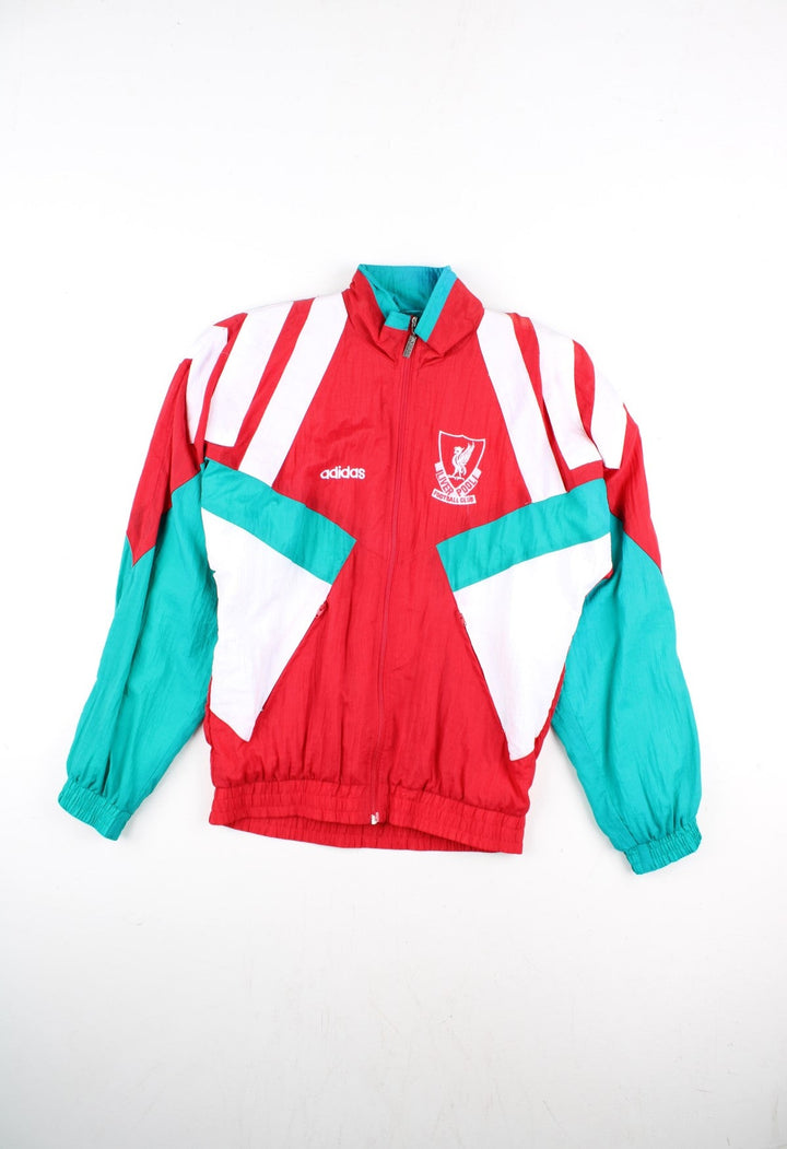 Vintage Adidas 92-93 Liverpool Track Top in a red colourway with green and white stripe panelling. Full zip with zip pockets and vintage Liverpool badge n the chest.