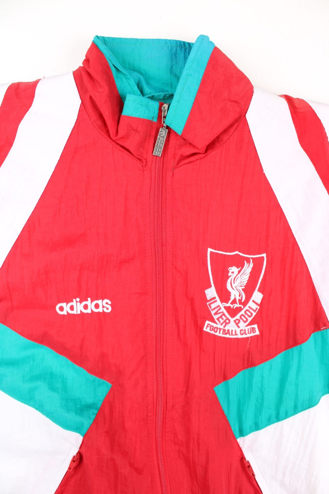 Vintage Adidas 92-93 Liverpool Track Top in a red colourway with green and white stripe panelling. Full zip with zip pockets and vintage Liverpool badge n the chest.