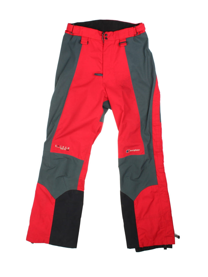 Berghaus Extrem Gore-Tex ski/alpine zip off salopettes in red with grey and black panelling, multiple pockets, zip and snap closure, velcro waist adjusters, embroidered logos, and toggles for braces to be attached.