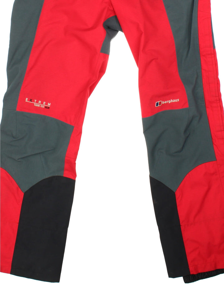 Berghaus Extrem Gore-Tex ski/alpine zip off salopettes in red with grey and black panelling, multiple pockets, zip and snap closure, velcro waist adjusters, embroidered logos, and toggles for braces to be attached.