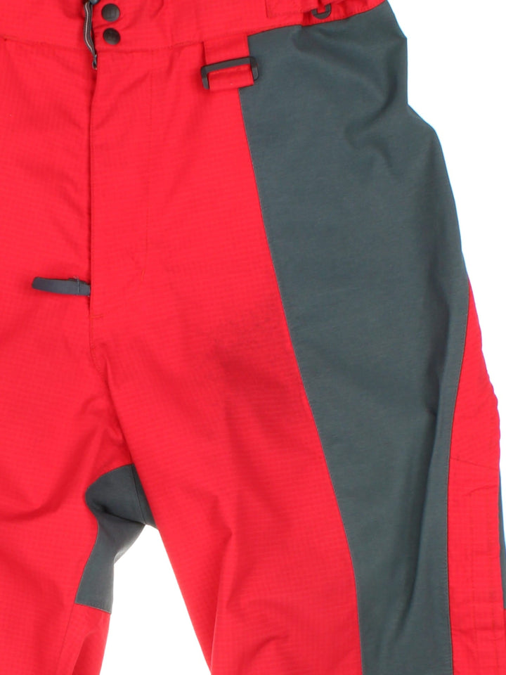 Berghaus Extrem Gore-Tex ski/alpine zip off salopettes in red with grey and black panelling, multiple pockets, zip and snap closure, velcro waist adjusters, embroidered logos, and toggles for braces to be attached.