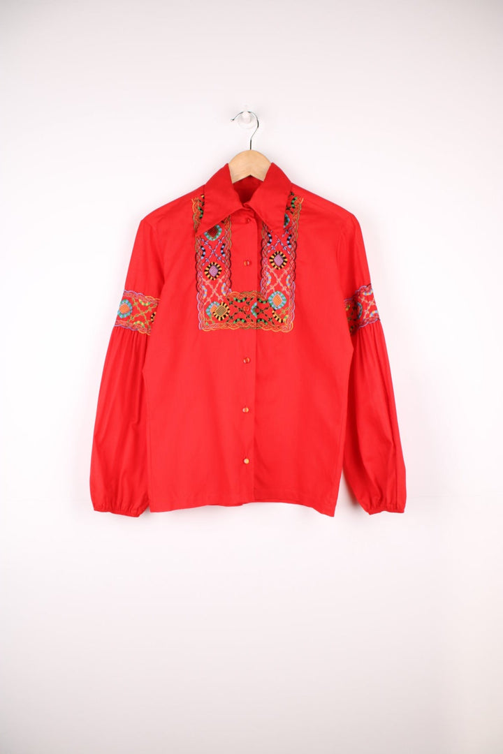 Red western blouse with a floral embroidered yoke and sleeves. 