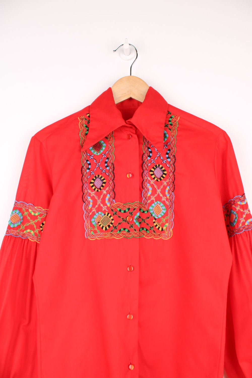 Red western blouse with a floral embroidered yoke and sleeves. 