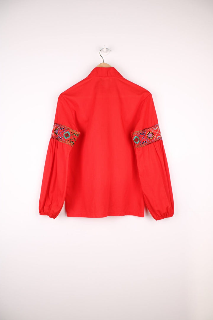 Red western blouse with a floral embroidered yoke and sleeves. 