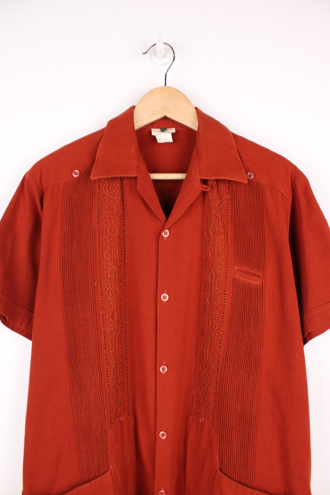 Burnt orange embroidered short-sleeved shirt with three pockets. 