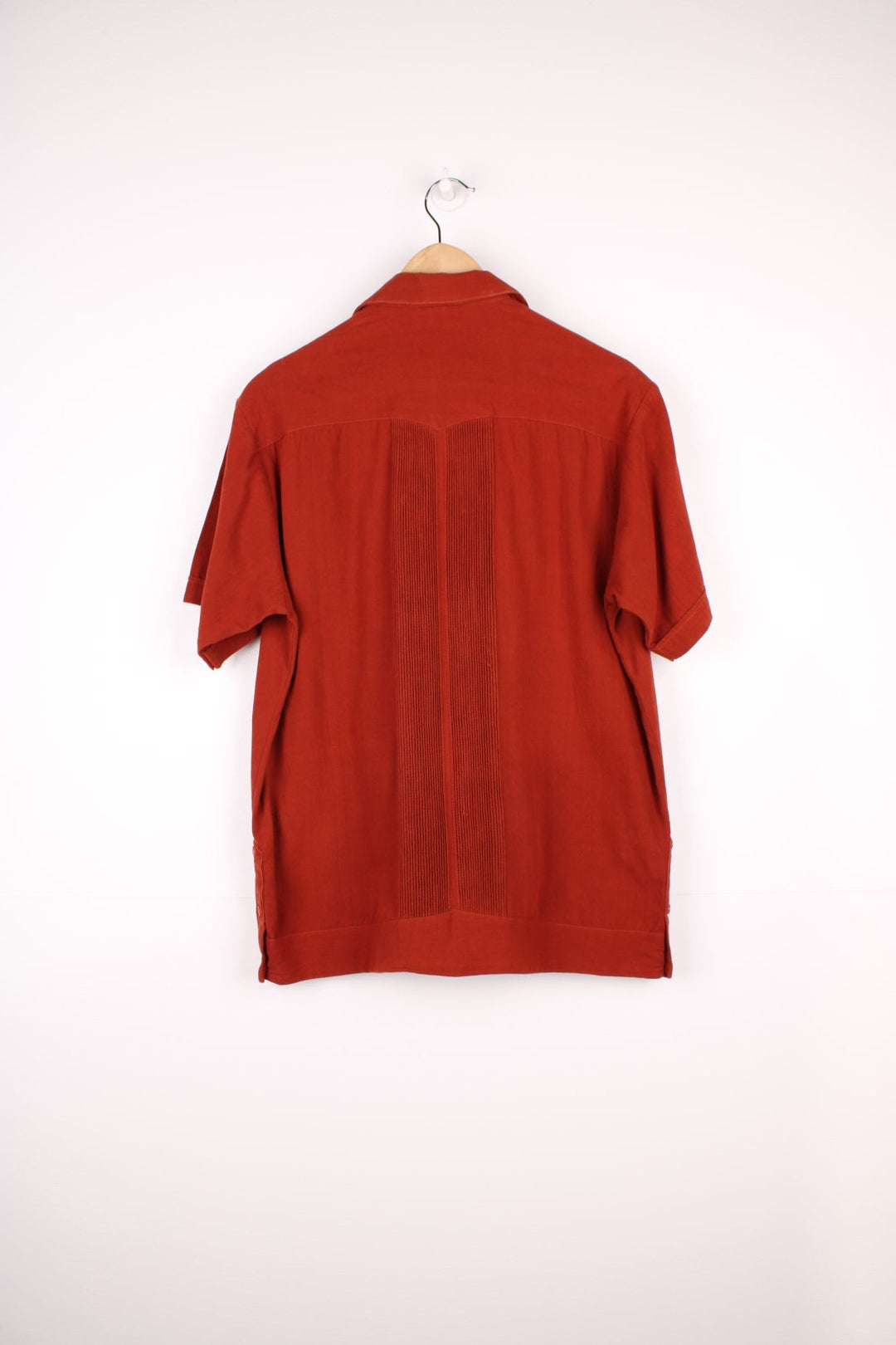 Burnt orange embroidered short-sleeved shirt with three pockets. 