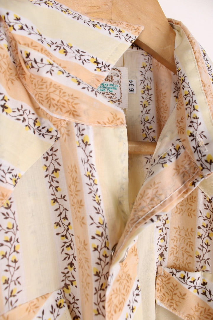 Pale yellow floral patterned short-sleeved shirt by HBarC with two flap pockets and pearl-effect snap closure. 