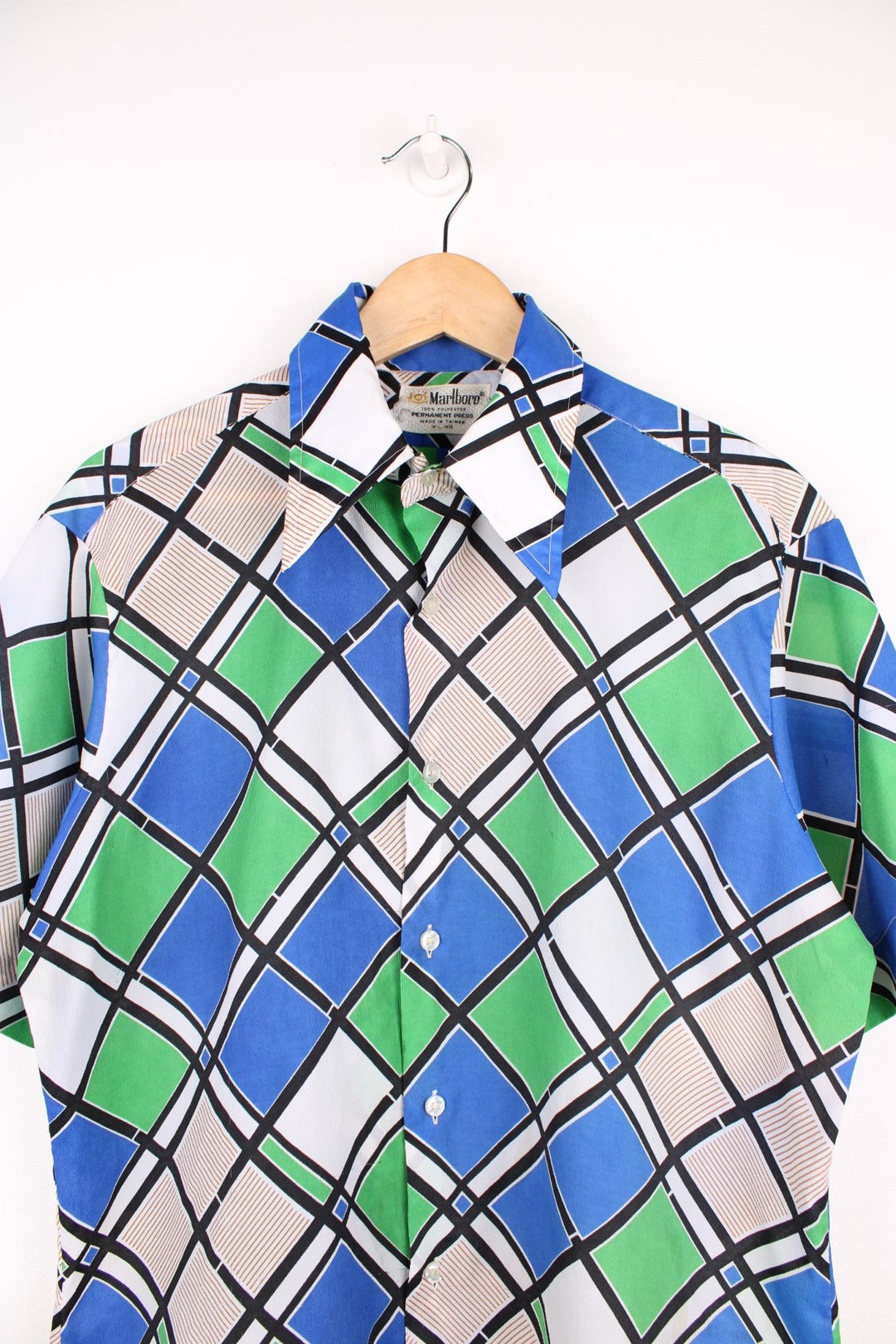 Blue and green geometric patterned short-sleeved shirt by Marlboro, with a dagger collar and buttons. 