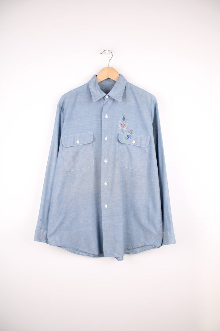 Grey western shirt with colourful embroidery on the front and back, with two flap pockets. 