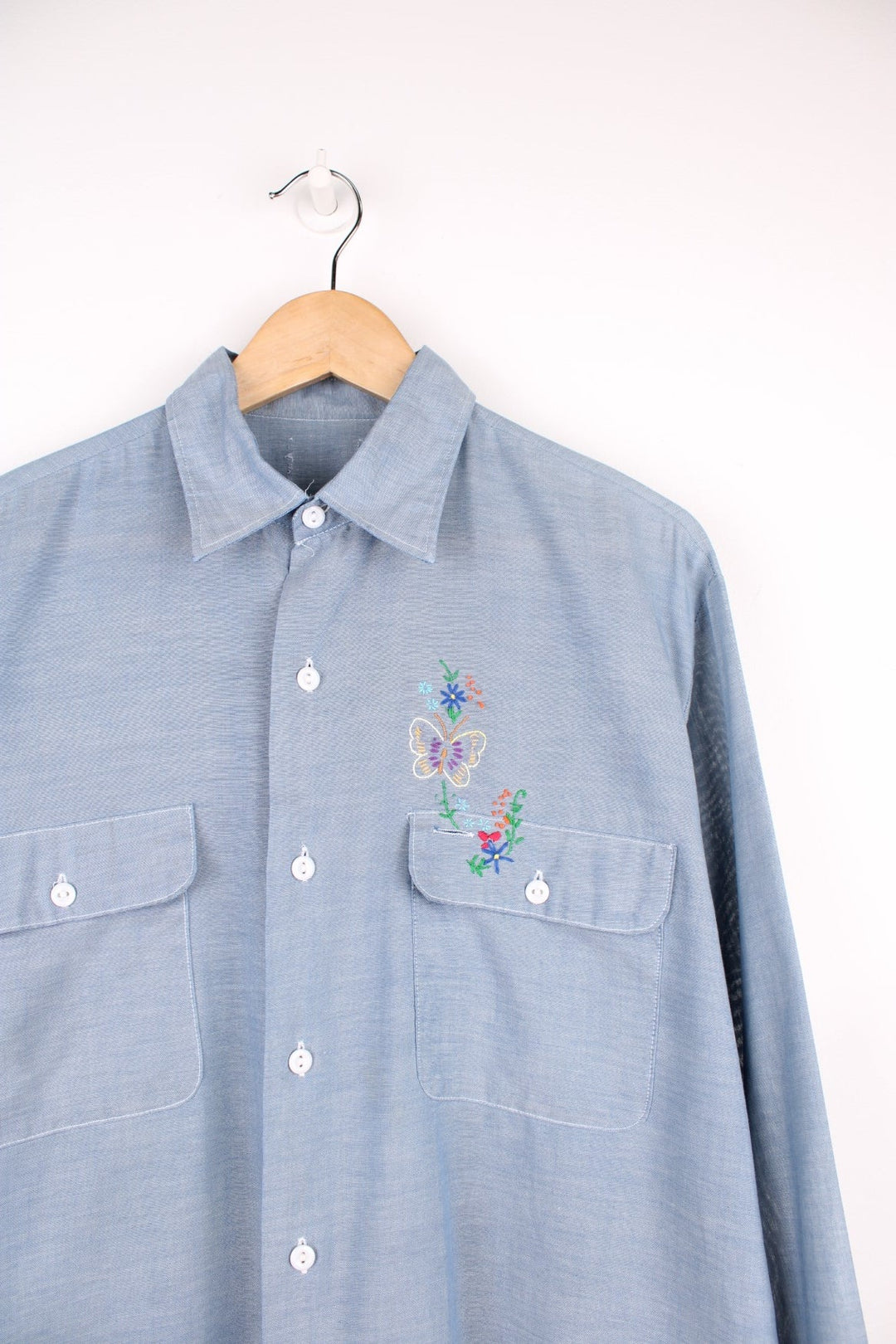 Grey western shirt with colourful embroidery on the front and back, with two flap pockets. 