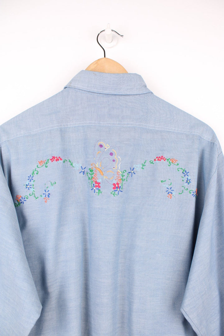 Grey western shirt with colourful embroidery on the front and back, with two flap pockets. 