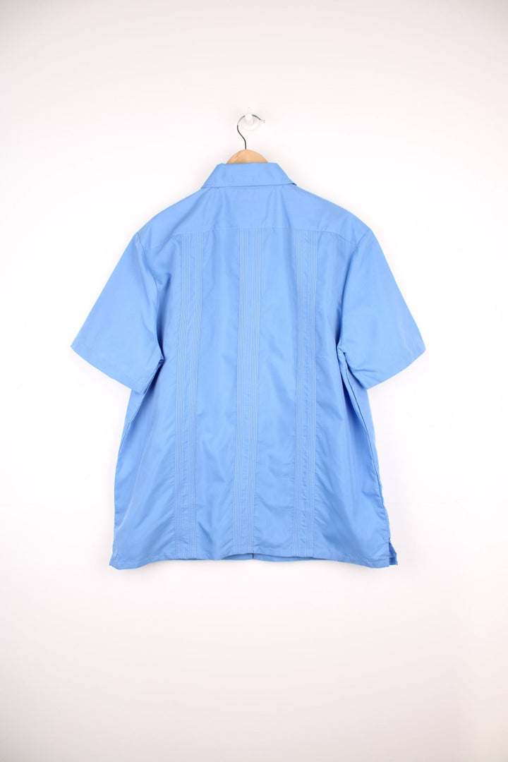 Blue short-sleeved embroidered Cuban shirt with four pockets and zip closure. 