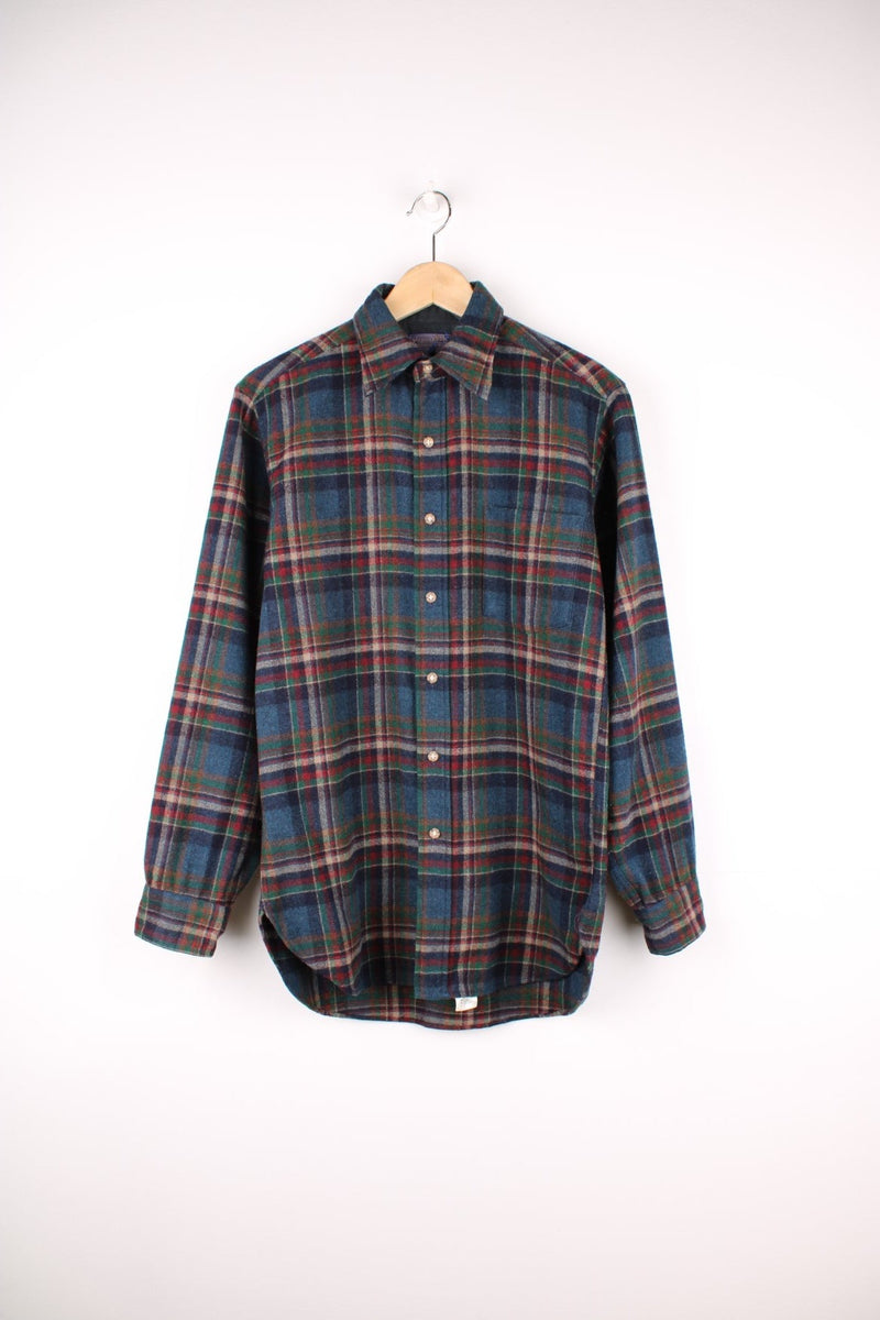 Dark blue, red and green plaid Pendleton shirt, 100% wool with one buttoned flap pocket.