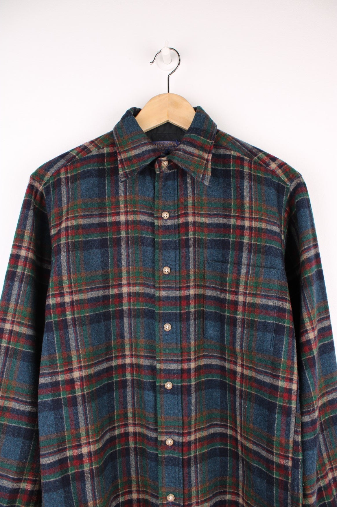 Dark blue, red and green plaid Pendleton shirt, 100% wool with one buttoned flap pocket.