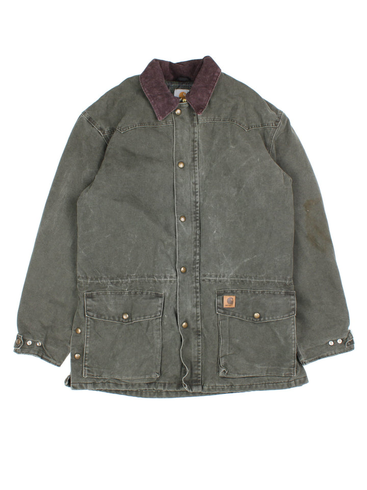 Vintage Carhartt Barn Chore Jacket in a green colourway. Buttons up and has double pockets on the front, brown corduroy collar, blanket lining, and has the logo embroidered on the front.